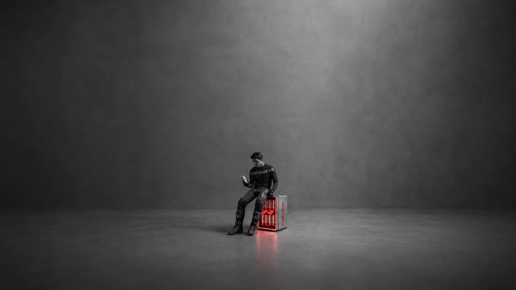 Natural athlete seated beside a cooler of Natural energy drinks